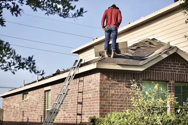 Professional roofer working on a residential roof in South Dennis